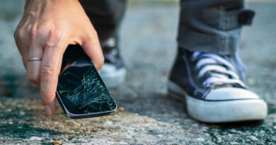 Mann, der ein kaputtes Smartphone vom Boden aufhebt