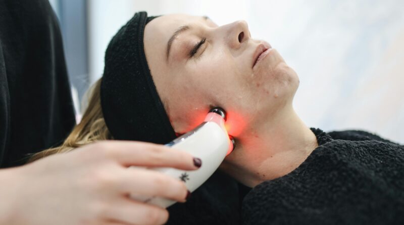 Frau erhält eine Gesichtspflege Behandlung mit roter Lichttherapie, eine moderne Technik zur Förderung einer gesunden und klaren Haut.