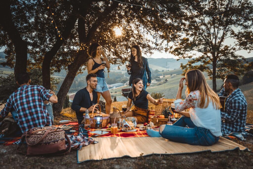 Gruppe von Freunden beim Essen, draußen in der Natur