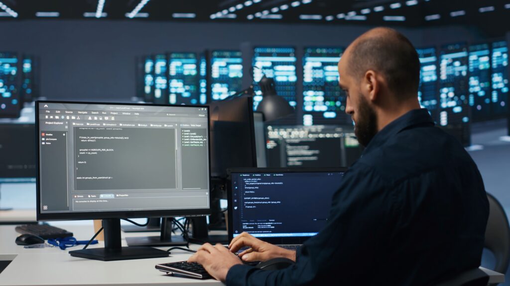 Eine Person sitzt an einem Laptop und programmiert etwas