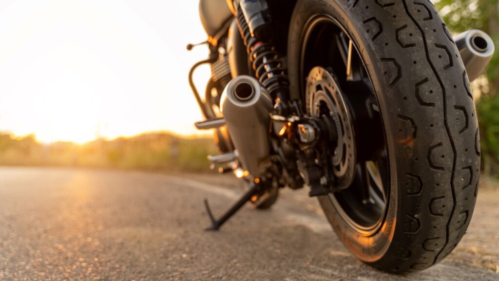 Nahaufnahme eines Motorrads auf der Straße bei Sonnenuntergang – Tipps für optimalen Motorrad Schutz gegen Wetter und Schäden.