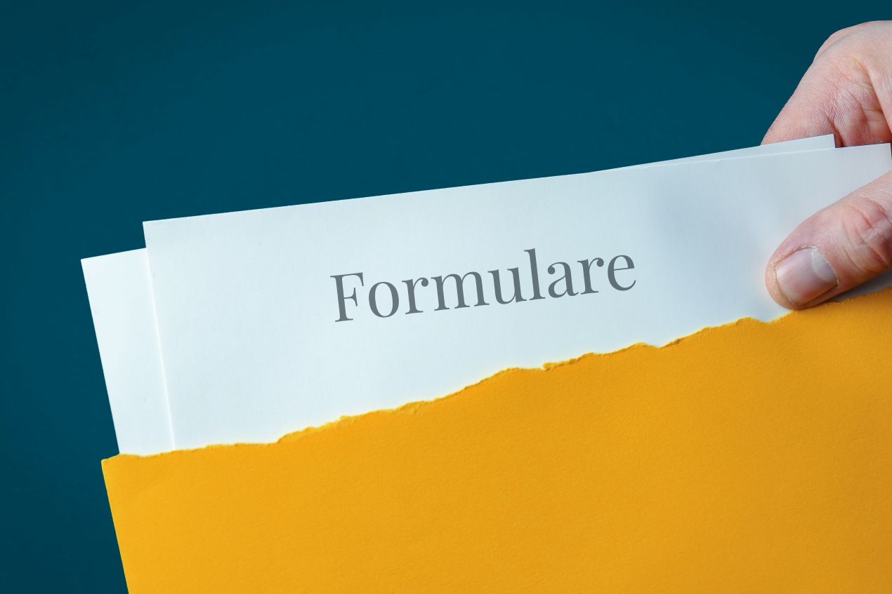Hand hält gelben Umschlag mit Dokumenten, auf denen „Formulare“ steht – Symbol für strukturierte Musterformulare im Büroalltag