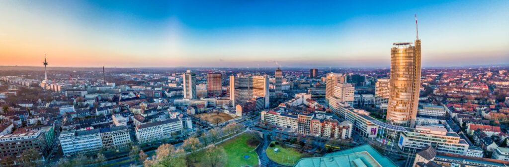 Panoramaaufnahme der Stadt Essen mit Skyline und zentralen Kliniken – Symbol fuer den Standortvorteil bei oralchirurgie essen