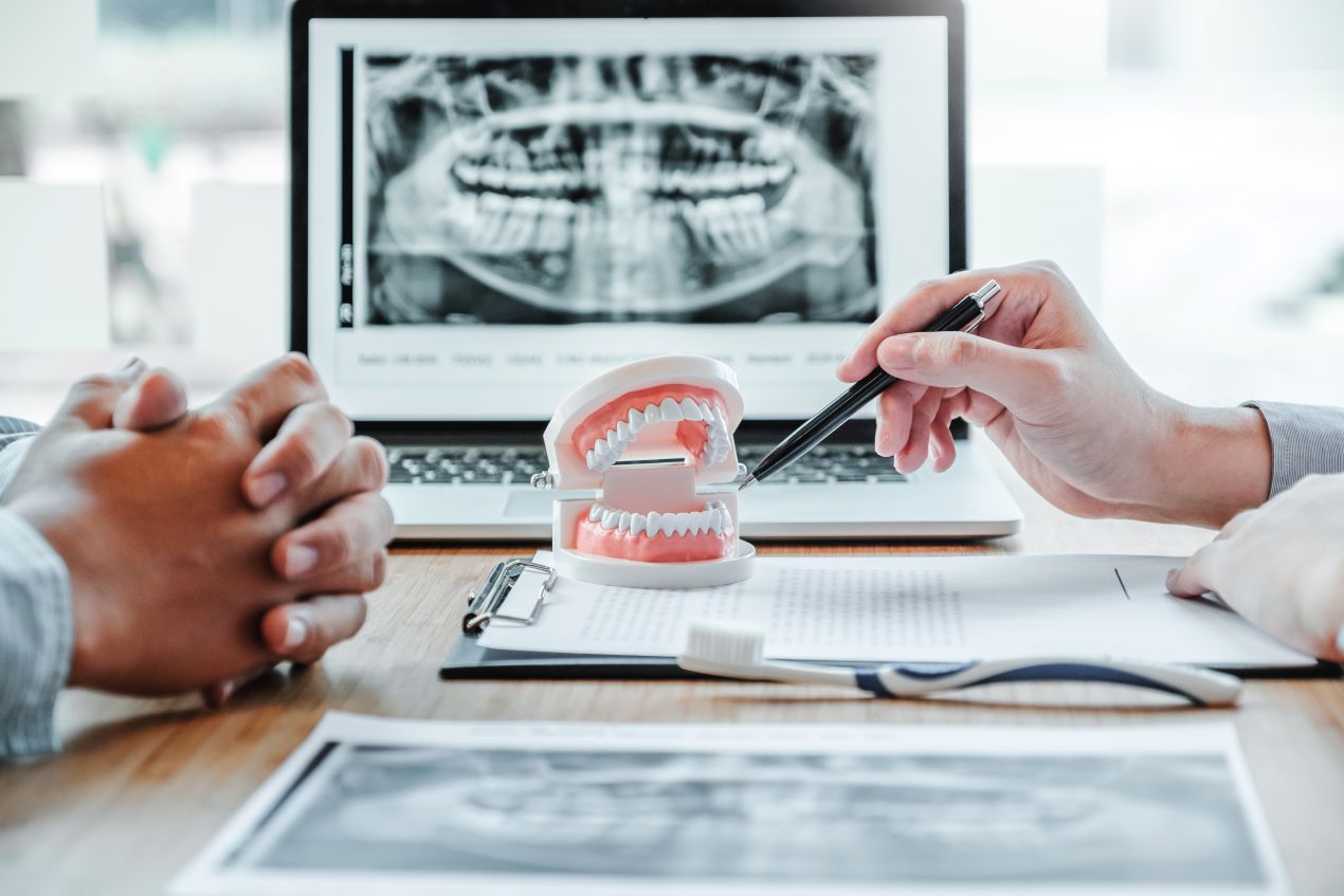 Ein Arzt erklaert anhand eines 3D-Kiefermodells und Roentgenbildes den Eingriff – Fokus auf patientenzentrierte oralchirurgie essen