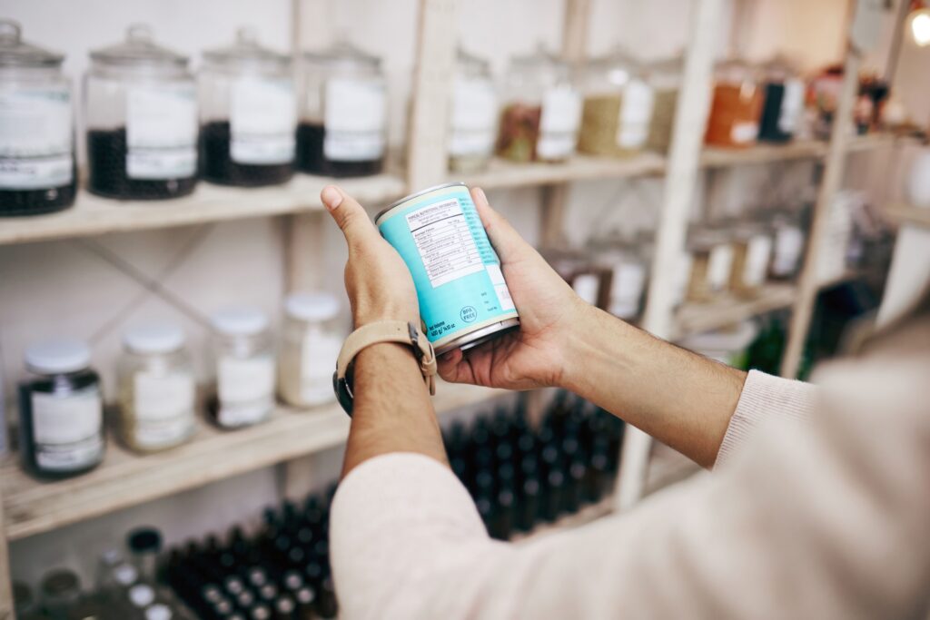 Person prüft Produktetikett im Regal – Etiketten drucken und richtig kennzeichnen