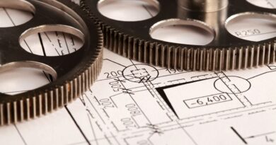 Zahnräder liegen auf einer technischen Zeichnung und symbolisieren Praezision, Konstruktion und systematische Anlagenplanung